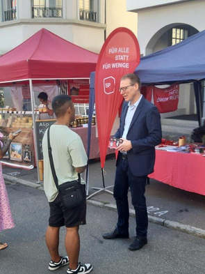 Die Foto zeigt den NR-Kandidaten Adrian Wüthrich im Gespräch mit einem Marktbesucher